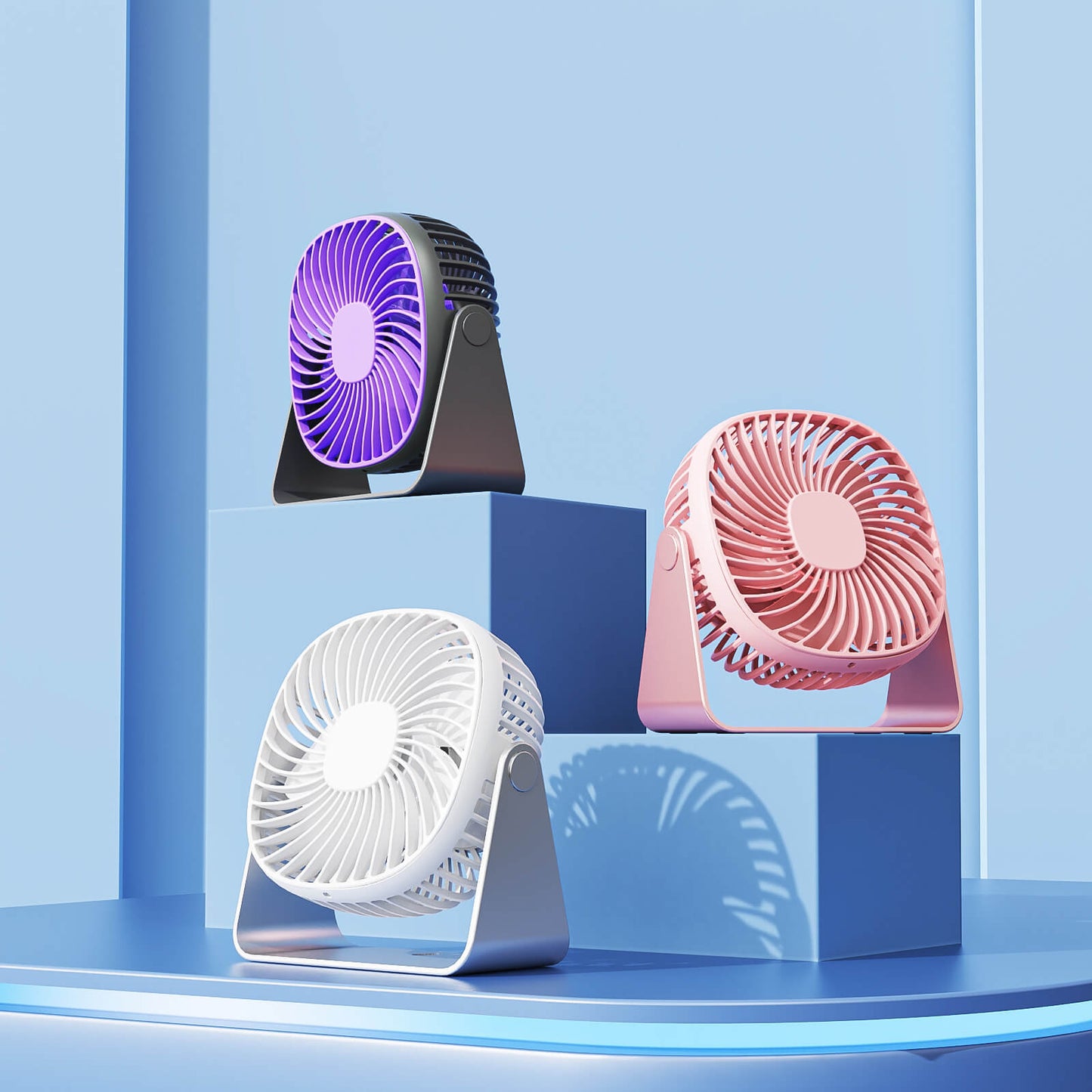  Three portable desk fans in purple, pink, and white, featuring compact foldable stands and colorful blade designs.
