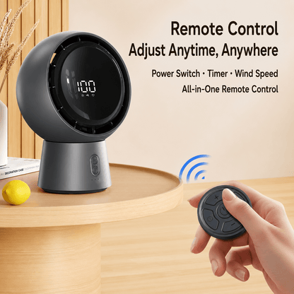 Gray spherical desktop fan being controlled by a wireless remote, featuring power switch, timer, and wind speed adjustment.
